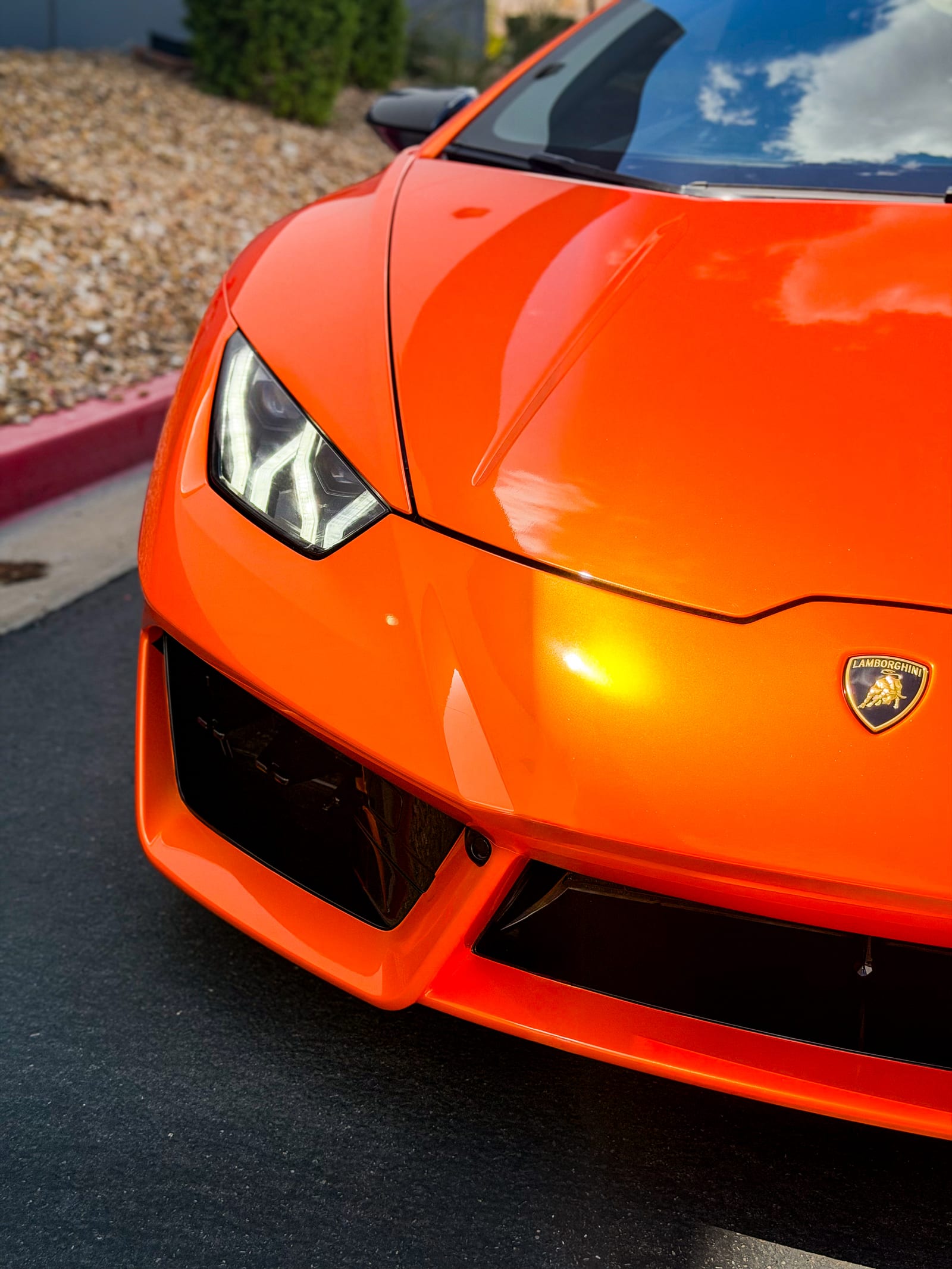lamborghini huracan wrap — close-up of the hood and headlight showing gold highlights in the orange vinyl