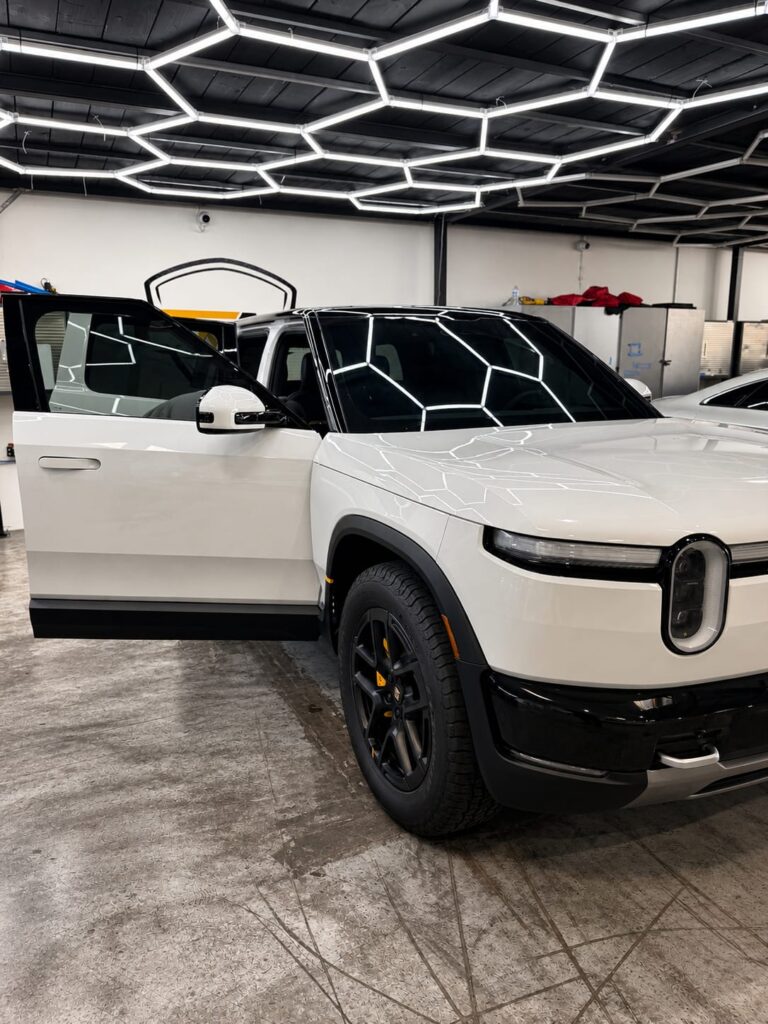 rivian r2 paint protection — Rivian R2 front three-quarter view with ceramic tinted windshield and windows