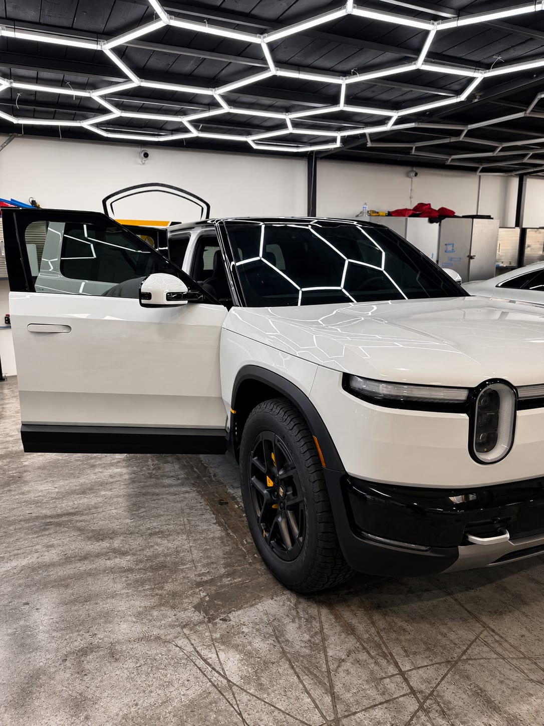 rivian r2 paint protection — Rivian R2 front three-quarter view with ceramic tinted windshield and windows