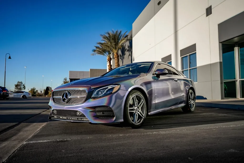 Mercedes-Benz E-Class coupe in an iridescent color-shift wrap outside Purple Flare Wraps